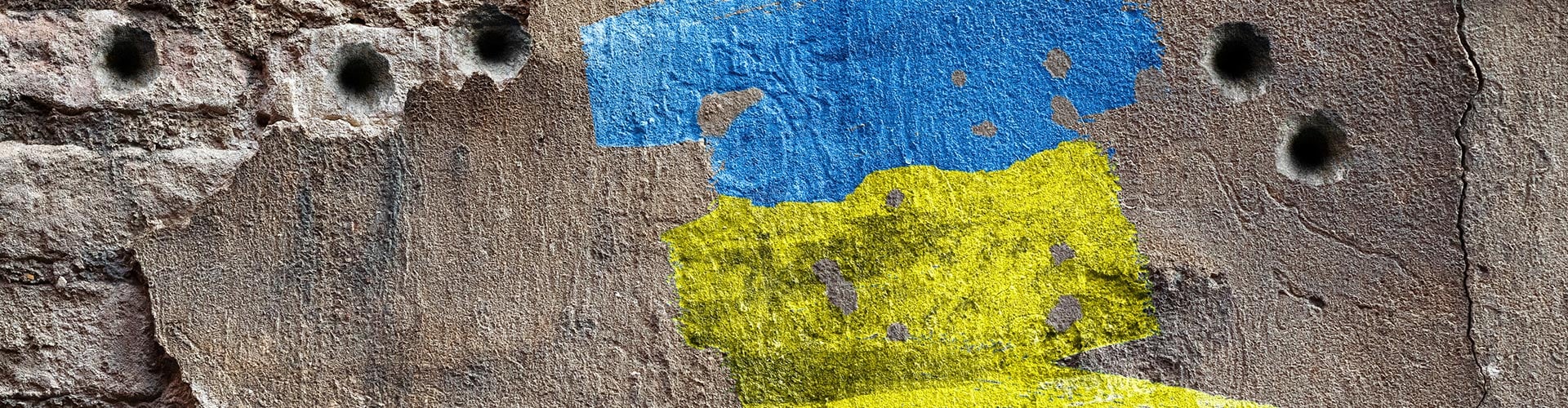 Ukraine flag on a wall with bullet holes